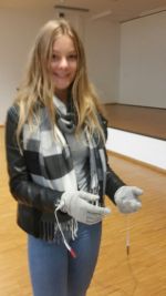 Eine Schülerin probiert Handschuhe an, die die Krankheit Parkinson simulieren.